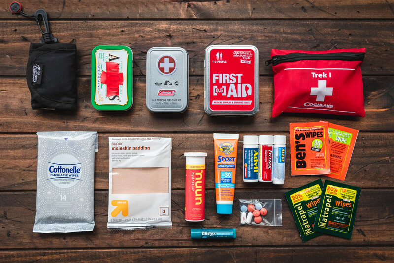 Flat lay of emergency first aid supplies organized on wood background.