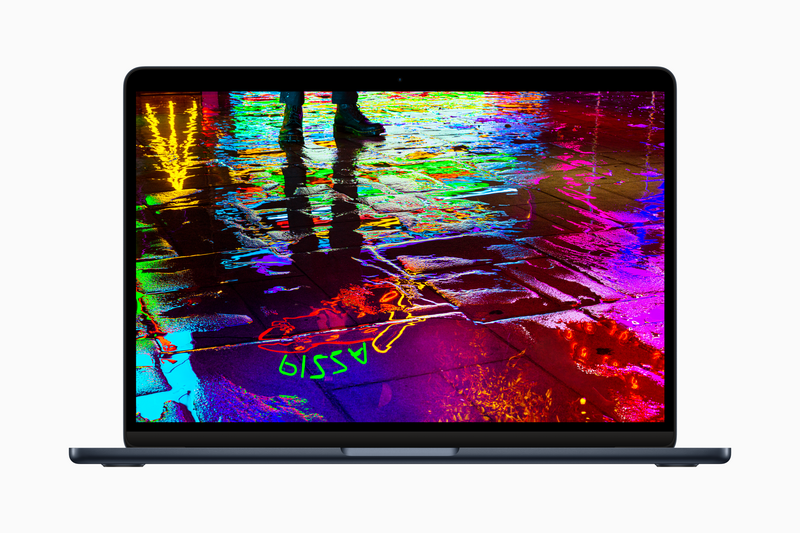 Laptop displaying vibrant, glitchy digital artwork with neon colors and distorted visual effects.