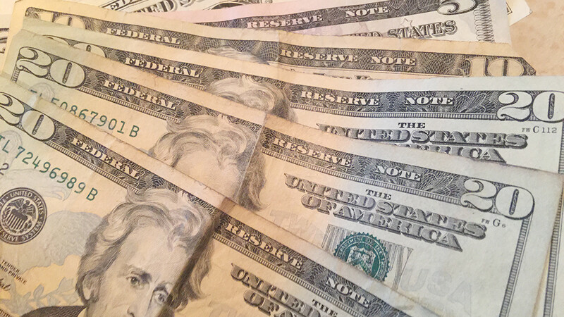 Multiple U.S. $20 bills arranged in an overlapping fan pattern, showing portraits and Federal Reserve markings.