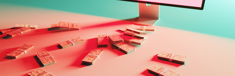 Red domino tiles arranged in curved lines on a pink surface, lit by red light from a monitor above.