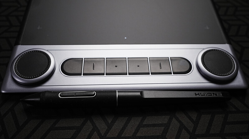 Top-down view of a portable audio device with dual rotary knobs and central button controls.