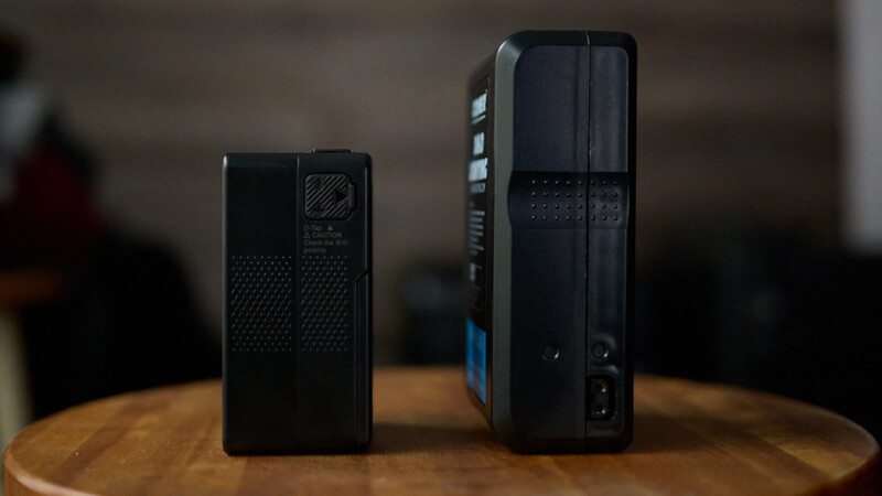 Two black uninterruptible power supply units of different sizes displayed side by side on a wooden table.