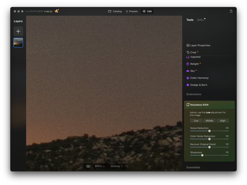 Screenshot of photo editing software showing a landscape image with warm-toned sky and dark rocky terrain.