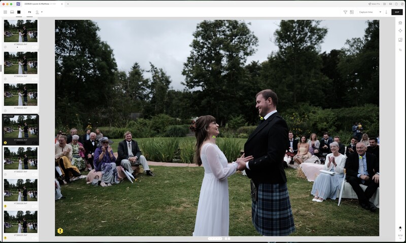 Bride and groom exchange vows during outdoor garden ceremony with seated guests surrounding them.