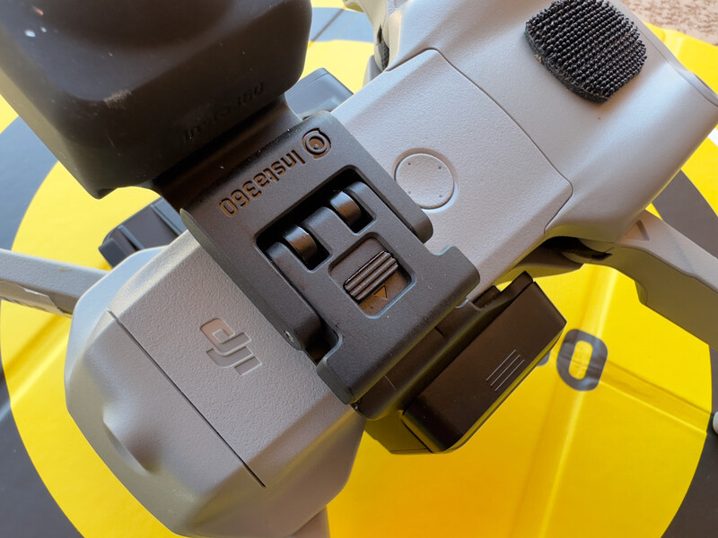 Top-down view of a portable audio recorder with control buttons and a microphone attachment on a bright yellow surface.