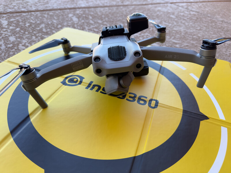 Drone positioned on yellow and black landing pad marked with concentric circles and text.