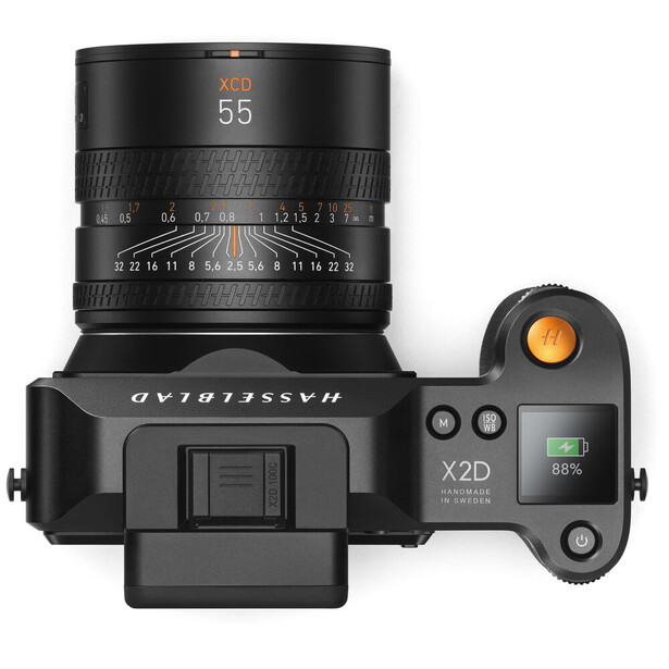 Top-down view of a mirrorless camera with a 55mm lens mounted and control dials visible on the right side.