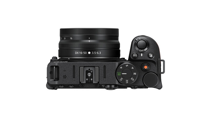 Top-down view of a mirrorless camera with attached zoom lens and control dials visible.