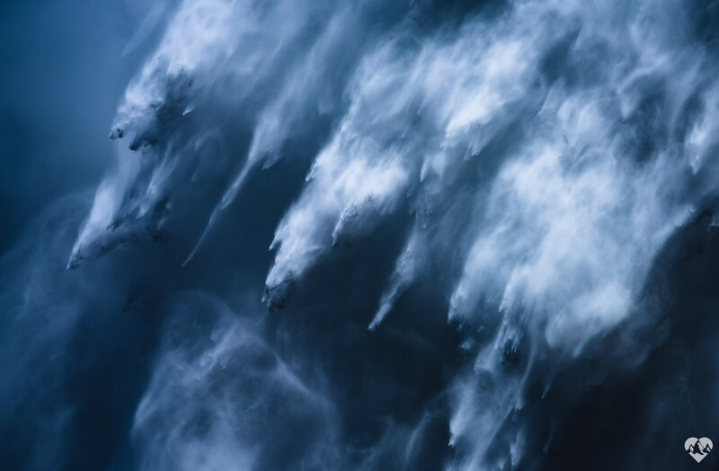 Aerial view of four jets performing a synchronized dive maneuver with dramatic contrails streaking through blue sky.