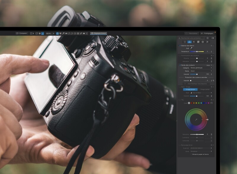 Screenshot of photo editing software displaying a camera held in hands during outdoor shooting.
