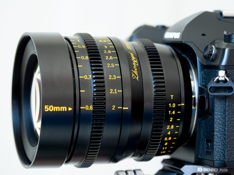Cinema lens mounted on digital camera body, showing focus and aperture markings in yellow text.