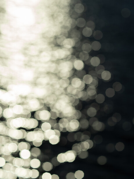 Defocused bokeh lights transitioning from warm white on the left to cool dark tones on the right.