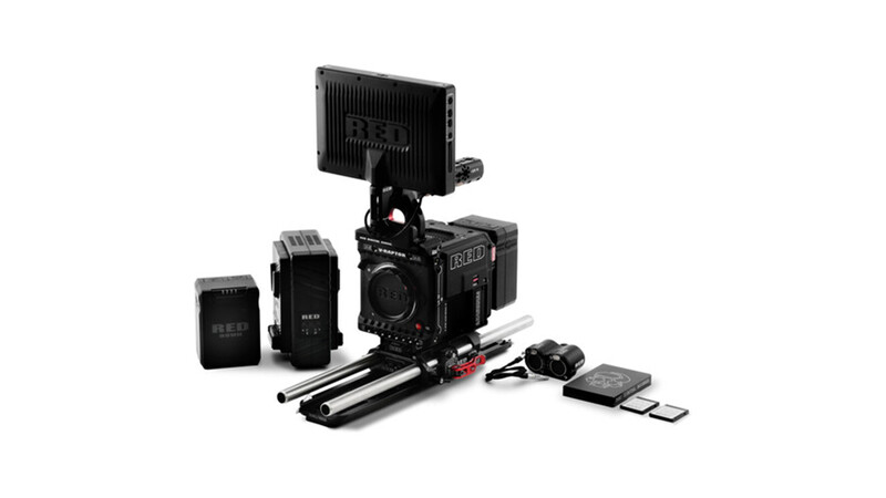 Professional cinema camera kit with monitor, wireless receivers, follow focus, and accessories arranged on white background.