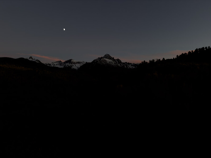 Silhouetted mountain range at twilight with a bright star visible in the darkening sky above.