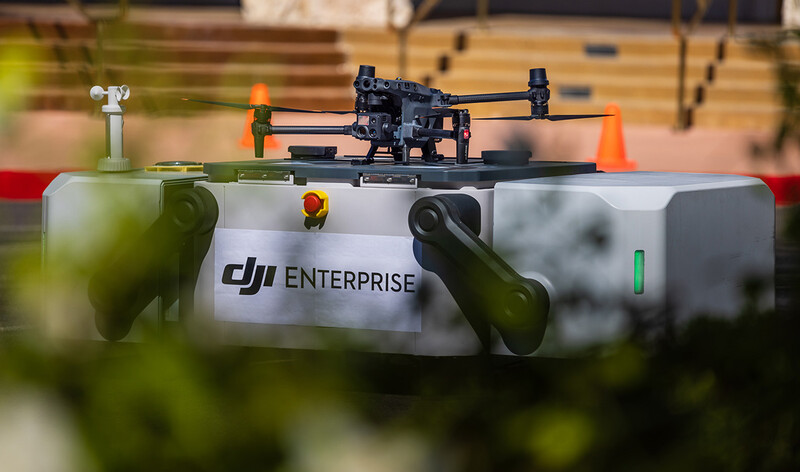 DJI Enterprise drone mounted on landing pad with charging station at outdoor test facility.