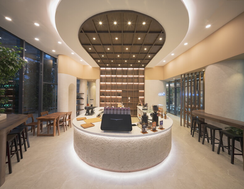 Modern circular retail counter with recessed ceiling lights and brown product display wall.
