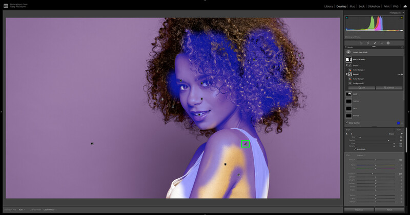 Portrait of a woman with curly brown hair against a purple background, lit with blue and warm yellow gel lighting.