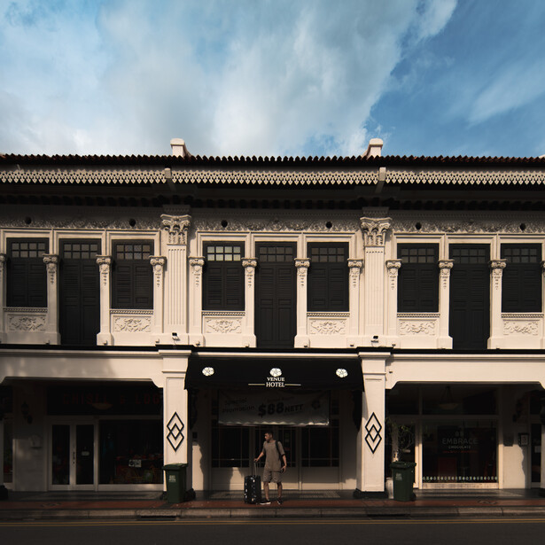 Colonial-style storefront with symmetrical black and cream facade and columned entrance.