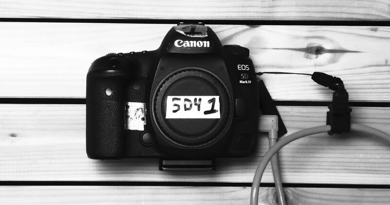 Canon EOS 5D Mark IV camera body displayed on white wooden surface with a reference card showing serial number 5541.