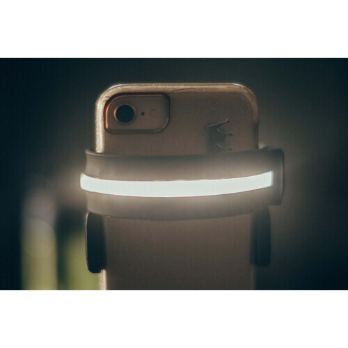 Smartphone mounted on a ring light with glowing white LED band against dark background.
