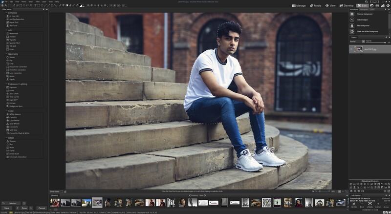 Young man in white t-shirt and jeans sitting on brick steps against urban brick wall background.
