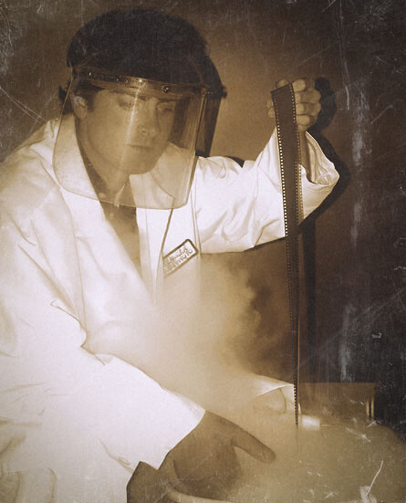 Person in white shirt adjusting camera on tripod against dark textured background.