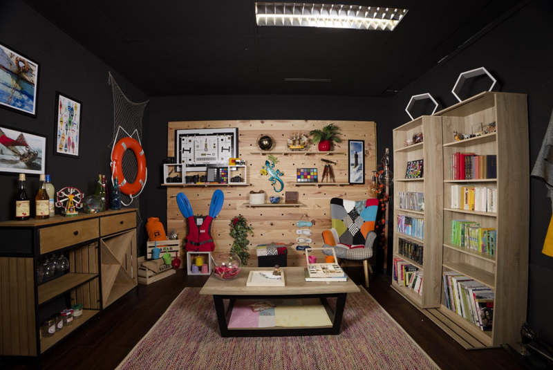 A creatively styled studio space with pegboard wall, wooden furniture, and colorful decorative objects arranged for display.