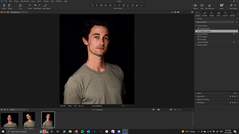 Portrait of a man wearing a gray t-shirt against a black background.