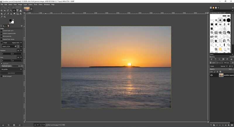 Screenshot of photo editing software displaying a seascape with sunset over water.