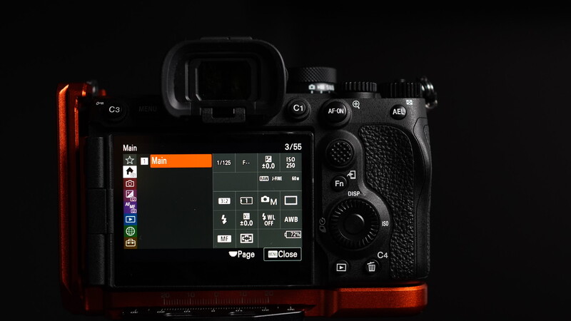 Mirrorless camera with rear LCD screen displaying menu settings, shown from overhead against black background with red accent lighting.