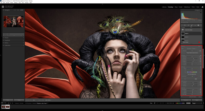 Woman with dramatic makeup and ornate headdress against flowing red fabric backdrop.