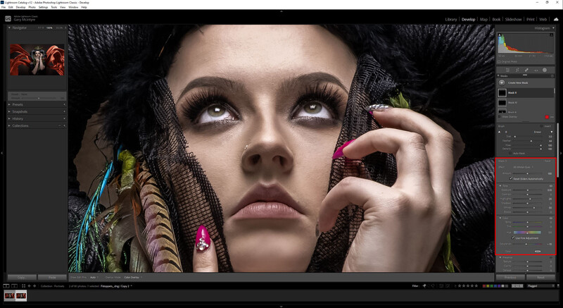 Woman's face with dramatic eye makeup and colorful feathered headdress against dark background.