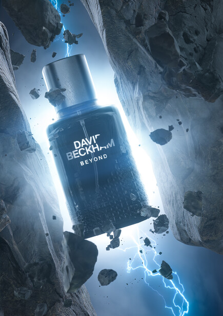 Product shot of a blue fragrance bottle suspended among floating rocky debris with blue lightning effects.