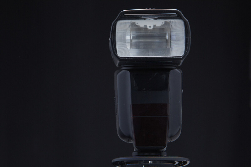 External camera flash unit shown against black background with front and side views visible.