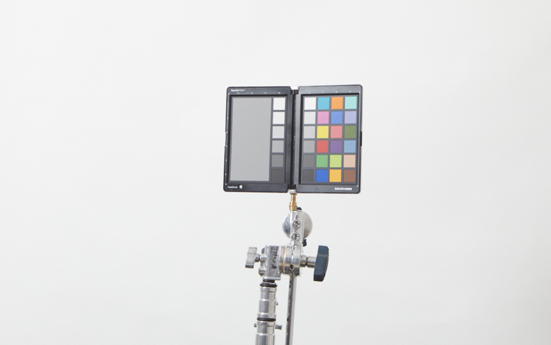 Color checker chart mounted on a lighting stand against a neutral backdrop.