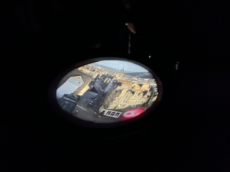 View through a periscope or telescope of an urban landscape with buildings and sky.