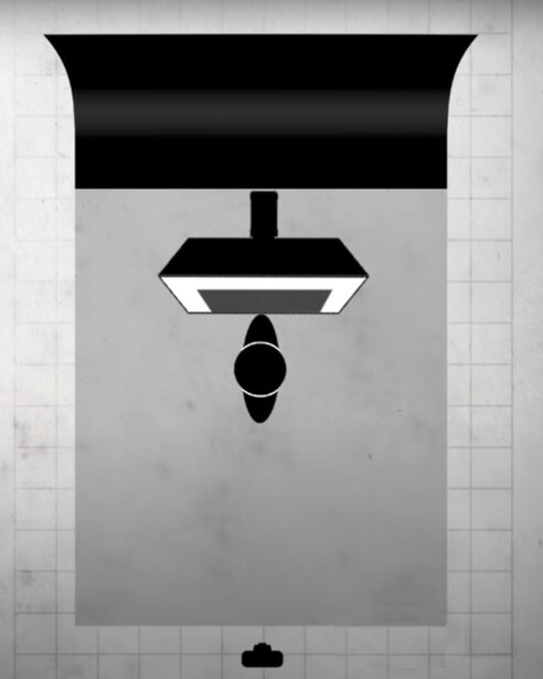 Overhead view of a person lying on a bed with geometric black and white bedding, shot directly from above.