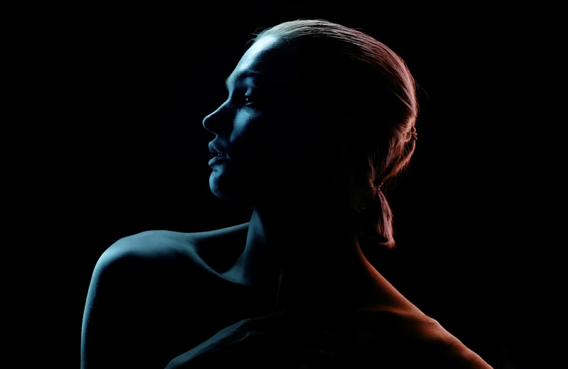 Profile silhouette of a person against black background with blue and orange rim lighting.