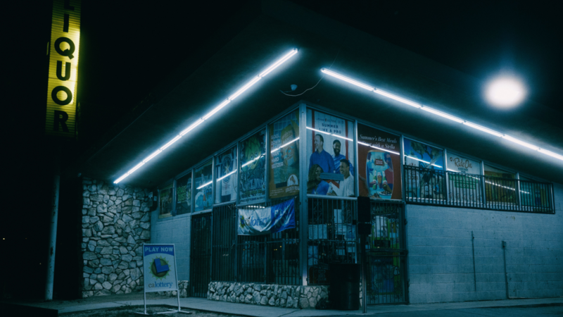 Modern library building illuminated by neon lights at night with glowing architectural outline.