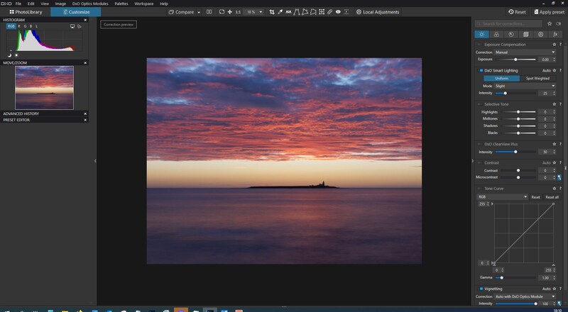 Sunset seascape with vibrant orange and purple clouds reflected in calm water, distant ship on horizon.