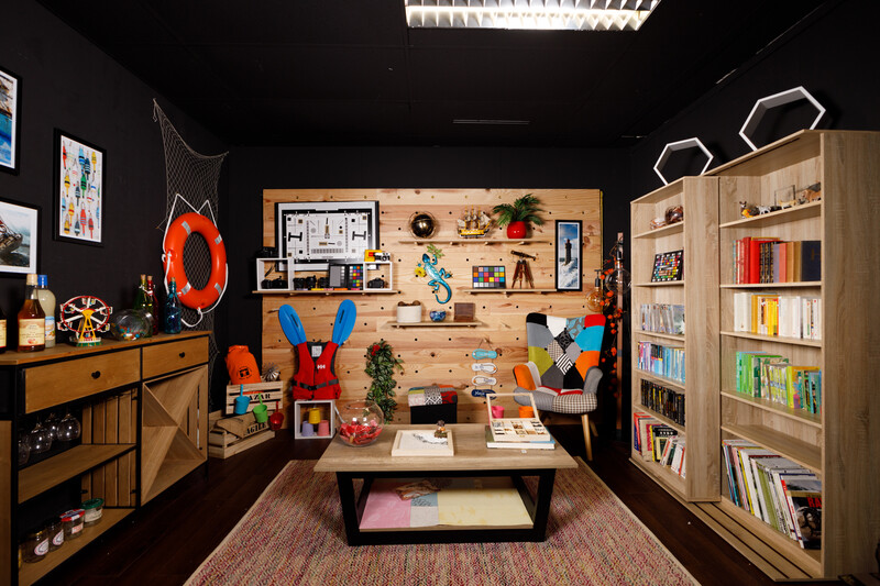 Colorful children's library room with pegboard wall, wooden shelving, and creative display elements.