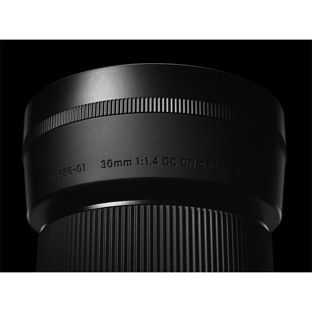 Close-up of a 36mm f/1.4 camera lens barrel against a black background.
