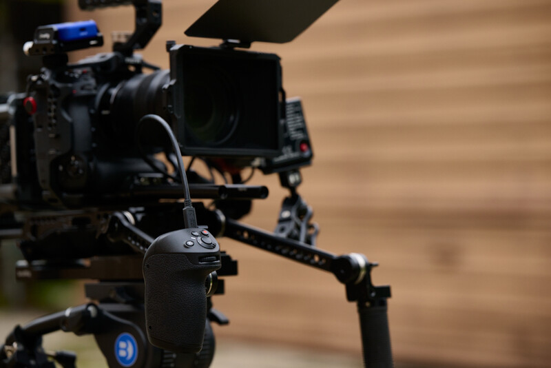 Professional cinema camera rig with wireless follow focus controller mounted on shoulder support system.