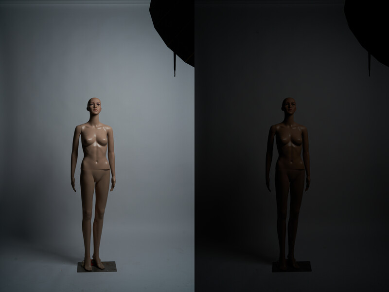 Two wooden mannequins standing upright against contrasting light and dark backgrounds.
