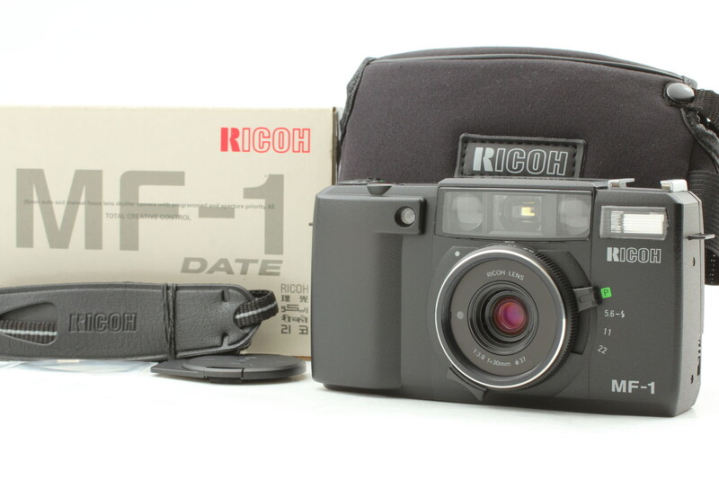 Ricoh MF-1 film camera with original box, instruction manual, and camera strap displayed.
