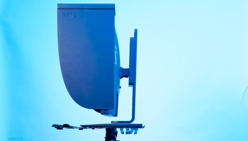 Blue satellite dish mounted on a pole against a clear light blue sky.