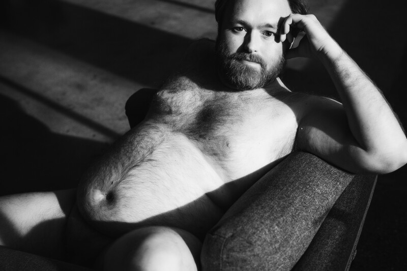 Shirtless man resting on couch