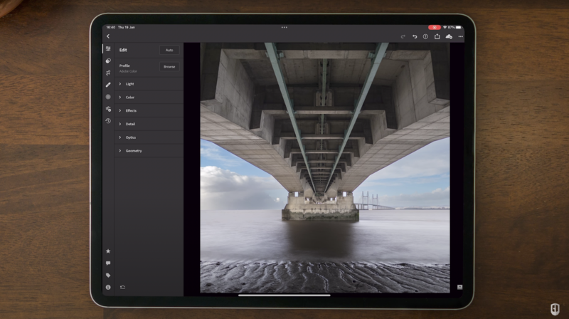 Screenshot of photo editing software displaying an architectural photograph of a bridge's underside with water and sky.