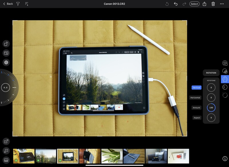 iPad displaying landscape photo editing interface on yellow quilted fabric workspace.