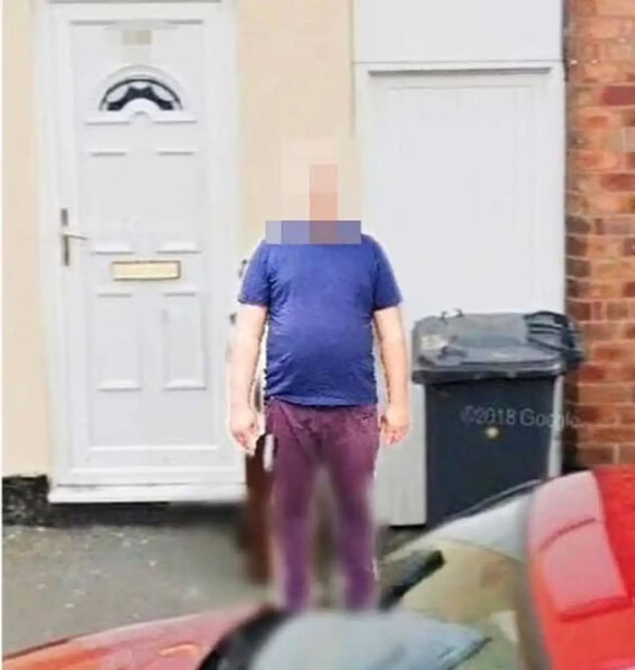 Person standing in front of a residential door and brick wall, face pixelated for privacy.